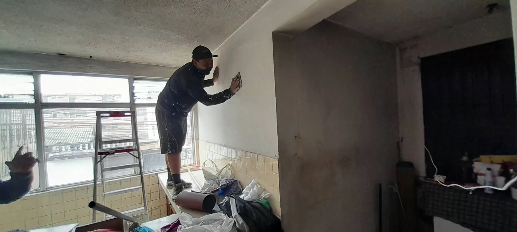 Trabajador realizando empastado de paredes en Quito